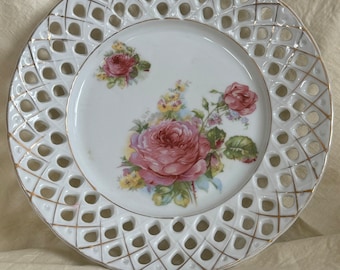 Antique decorative plate with gilded lattice edges with painted pink roses