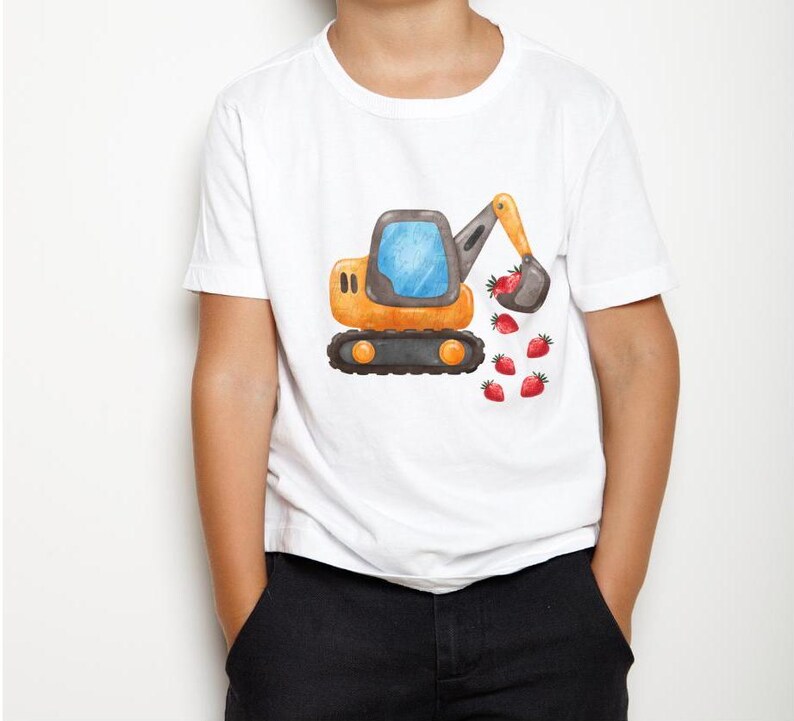 May include: A white t-shirt featuring a cartoon illustration of a yellow excavator digging up strawberries. The excavator has a blue cab and a black arm.