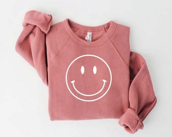 pink jumper with red smiley faces