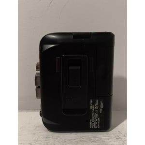 May include: Black Sony WM-FX301 radio cassette player with a silver face and a black belt clip. The text on the player reads "SONY WM-FX301 RADIO CASSETTE PLAYER BATTERY SUPPLY 1.5VX2 REC, JIS R6 SIZE AA OR EQUIV SONY CORP MADE IN MALAY"