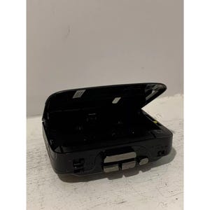 May include: Black cassette player with the lid open. The player has a silver button on the front and the text "SONY" is visible on the side.