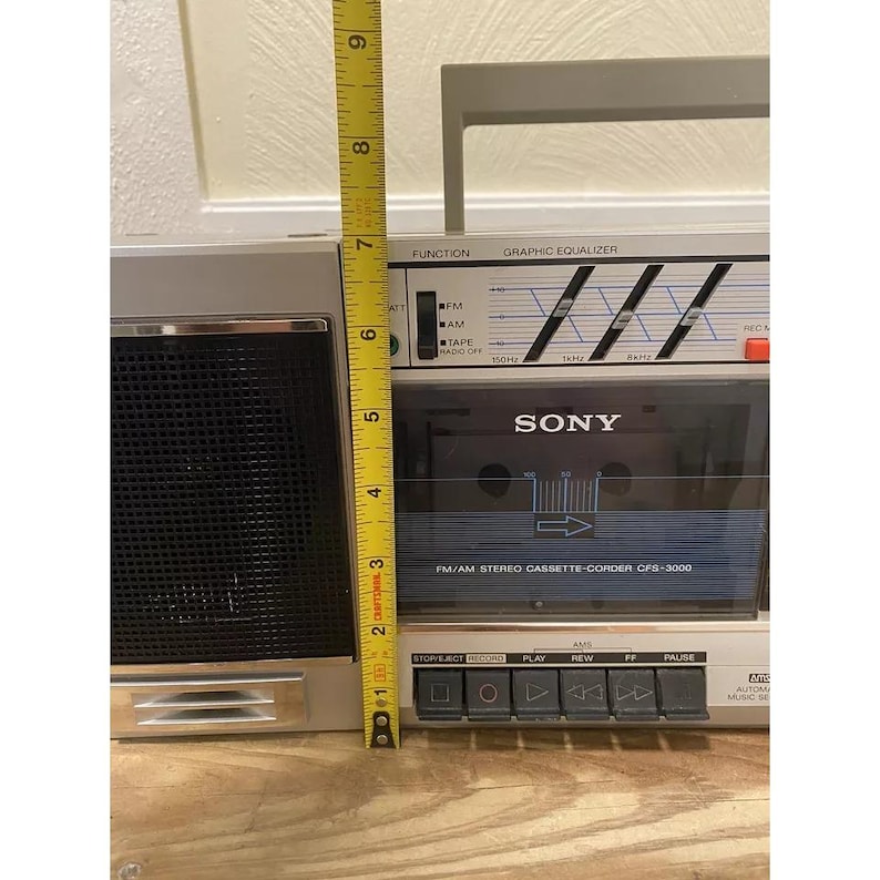 May include: A silver Sony CFS-3000 AM/FM Stereo Cassette-Corder with a graphic equalizer, tape deck, and a set of buttons for playback, rewind, fast forward, and pause.