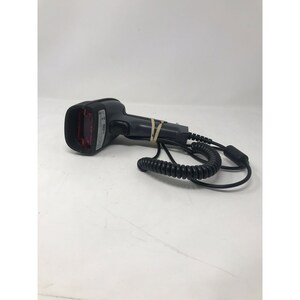 May include: A black barcode scanner with a red light window. The scanner has a coiled cord and a black handle. A rubber band secures the cord to the handle. The scanner is on a white surface.