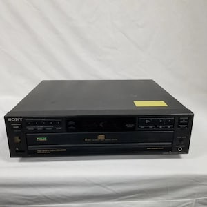 May include: A black Sony 5-Disc Automatic Disc Loading System CD player with a silver faceplate and a digital display. The player has a pulse button, a high density linear converter, and a headphone jack.