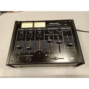May include: A black Realistic Stereo Mixing Console with three channels, each with a pan pot, a level control, and a cue/aux switch. The console also has a master volume control, a stereo/mono switch, and a fader.