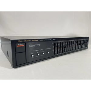 May include: Black Fisher EQ-213 stereo graphic equaliser. The audio component features a series of sliders for frequency adjustment, with the text "Studio-Standard by FISHER" and "STEREO GRAPHIC EQUALIZER EQ-213" visible. The power button is orange.
