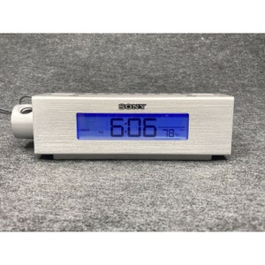 May include: A silver Sony clock radio with a blue digital display showing the time 6:06 PM and the temperature 78 degrees Fahrenheit.