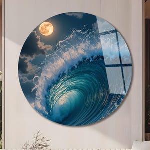 Puede incluir: Arte mural redondo que representa una ola rompiendo bajo la luna llena. La ola es turquesa, con espuma blanca y un cielo azul oscuro. La luna es amarilla y la obra se exhibe en una pared blanca. Diámetro aproximado de 76 cm.
