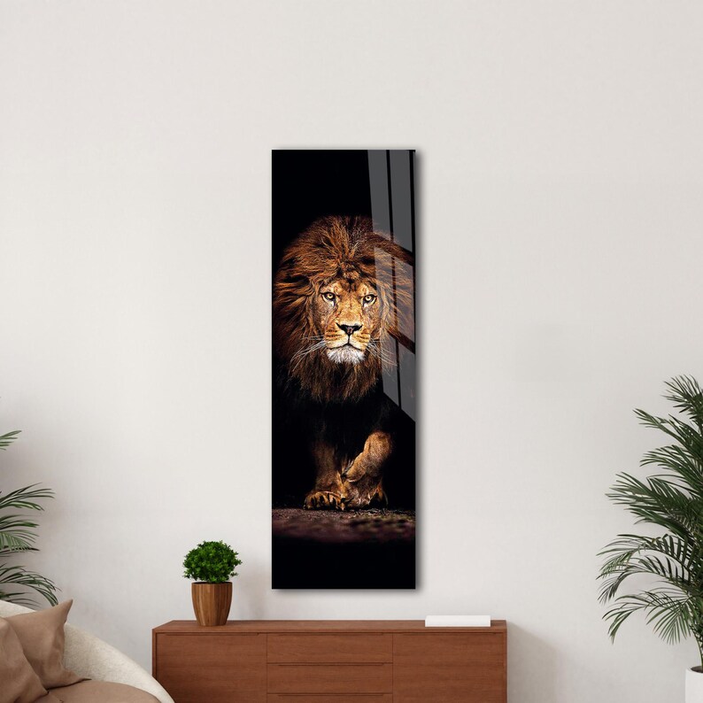May include: A vertical art piece featuring a majestic lion. The lion has a full, brown mane and is set against a dark background. The artwork is displayed on a wall, adding a touch of wildlife to the decor.
