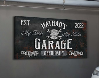 May include: Black and white garage sign with the text "EST. 2022 Nathan's Garage My Tools My Rules Open Daily". The sign has a distressed look with rusty accents.