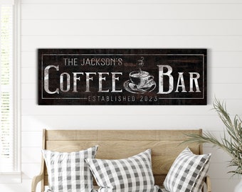 May include: A rustic wooden sign with the text "The Jackson's Coffee Bar - Established 2023" in white lettering. A stylised coffee cup with steam rising from it is centred between the words "Coffee" and "Bar".