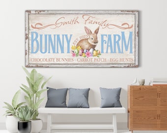May include: A rustic wooden sign with the text "Smith Family Bunny Farm Est. 2023 Chocolate Bunnies - Carrot Patch - Egg Hunts" in pink and blue lettering. A cartoon bunny with brown fur and pink ears is holding a basket of colorful eggs.