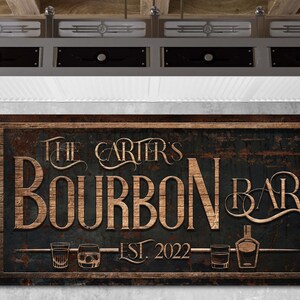 May include: A rustic wooden sign with the text "The Carter's Bourbon Bar Est. 2022" in gold lettering. The sign has a distressed, weathered look and features three glasses of bourbon and a bottle of bourbon.
