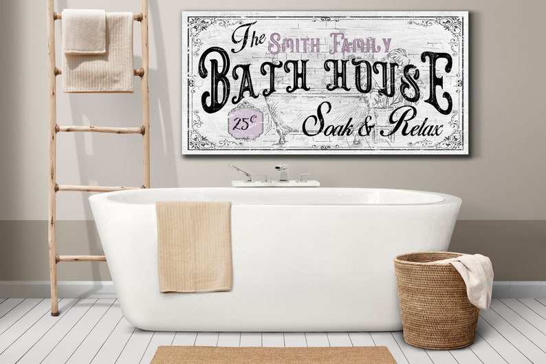 May include: White bathroom sign with black text that reads "The Smith Family Bath House 25&cent; Soak & Relax". The sign is hanging above a white bathtub with a beige towel hanging on the side.