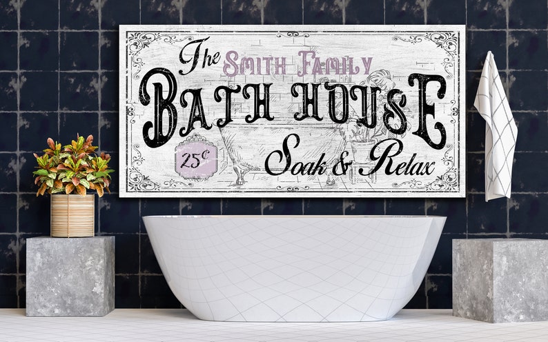 May include: A white wooden sign with black lettering that reads "The Smith Family Bath House 25&cent; Soak & Relax". The sign is hanging above a white bathtub in a bathroom with dark blue tile.