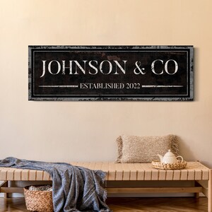 May include: Black and white sign with the text "JOHNSON & CO ESTABLISHED 2022" on a distressed wood background.