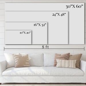 May include: A white sofa with pillows in front of a white wall with four different sizes of blank canvases hanging on the wall. The canvases are labeled with their dimensions in inches. The largest canvas is 30 inches by 60 inches, the next largest is 24 inches by 48 inches, the next is 16 inches by 32 inches, and the smallest is 10 inches by 20 inches. The wall is also labeled with a measurement of 5 feet.