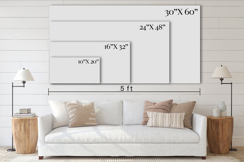 May include: A white sofa with pillows in front of a white wall with four different sizes of blank canvases hanging on the wall. The canvases are labeled with their dimensions in inches. The largest canvas is 30 inches by 60 inches, the next largest is 24 inches by 48 inches, the next is 16 inches by 32 inches, and the smallest is 10 inches by 20 inches. The wall is also labeled with a measurement of 5 feet.