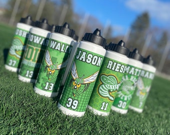 Puede incluir: Una colección de botellas de agua de plástico blanco con tapas de rosca negras. Cada botella presenta un gráfico verde de un avispón, un nombre de jugador como JASON, WALLY o RIESS, y un número como 39, 13 o 11 en una fuente negrita.