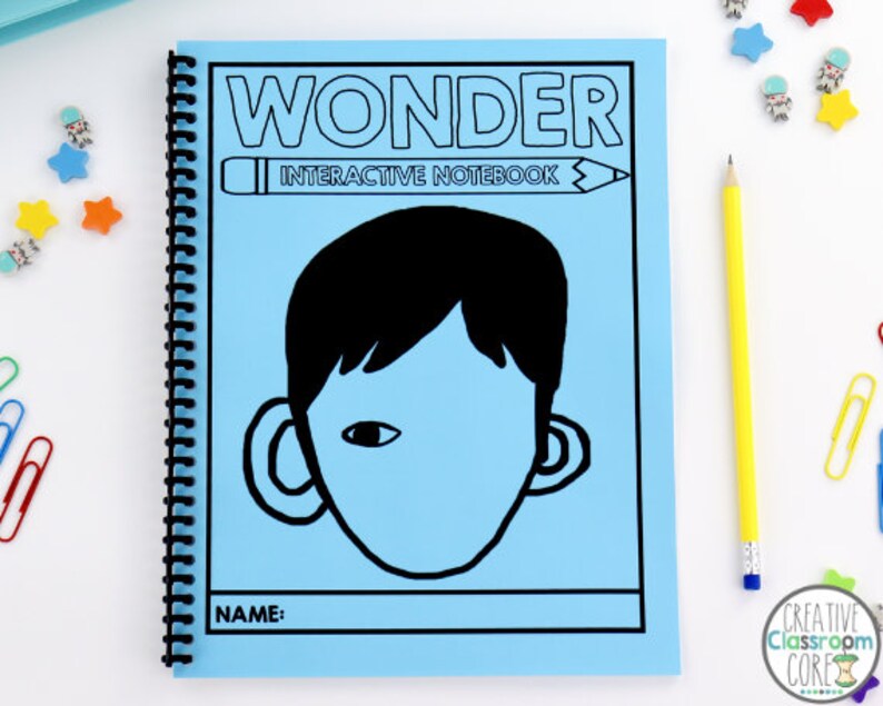 Pode incluir: Uma capa de caderno interativo azul com a palavra "WONDER" em letras pretas e as palavras "Interactive Notebook" em letras pretas menores. Uma ilustra&ccedil;&atilde;o em preto e branco de um rosto com uma orelha grande de cada lado est&aacute; no centro da capa. As palavras "NAME:" est&atilde;o na parte inferior da capa.