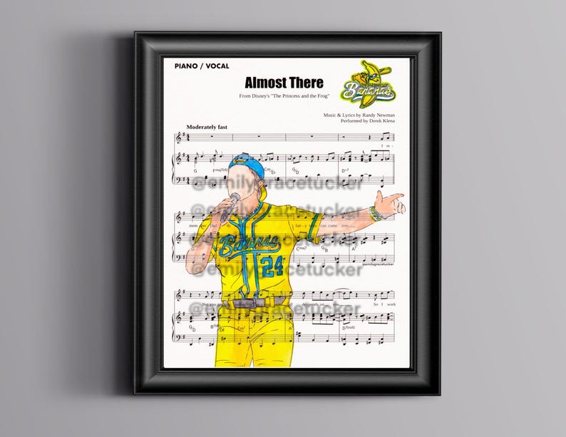 May include: Framed print of sheet music for "Almost There" from Disney's "The Princess and the Frog." The artwork features a cartoon illustration of a performer in a yellow baseball uniform with the number 24, singing into a microphone.