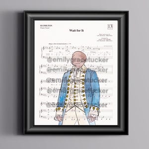 May include: Framed print featuring sheet music and a watercolor illustration of a figure in a blue coat. The text "Wait for It" is visible at the top. The artwork is in a black frame.
