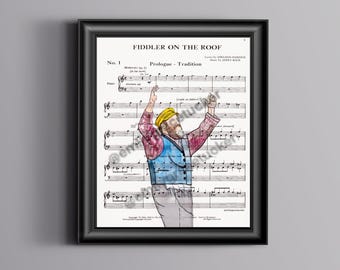 Puede incluir: Impresión enmarcada de partituras de "Fiddler on the Roof". La obra presenta una colorida ilustración de un hombre con los brazos levantados, con un sombrero amarillo, un chaleco azul y una camisa estampada en rojo y rosa. La impresión está en un marco negro.