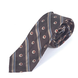 May include: A brown tie with a repeating pattern of red and white circular designs. The tie has vertical stripes in brown, tan, and blue. The tie is rolled up on a white background.