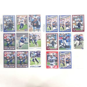May include: A collection of Frank Wycheck football trading cards, featuring the player in action. The cards display the Titans' team colors of navy, white, and light blue. Some cards are in protective sleeves, and the cards are arranged in rows.