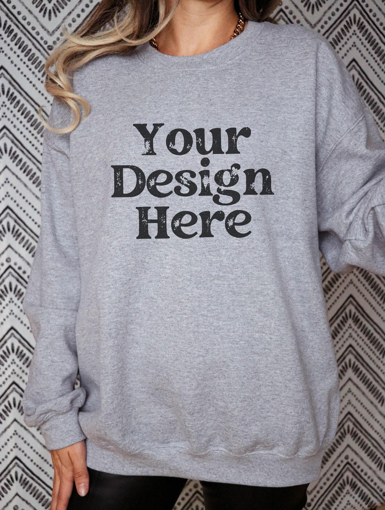 Puede incluir: Una sudadera gris con el texto "Your Design Here" impreso en la parte delantera.