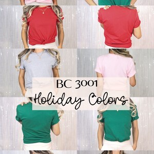 Pu&ograve; includere: Un collage di otto foto che mostrano una variet&agrave; di t-shirt in colori festivi. Le t-shirt sono tutte dello stesso stile, con collo rotondo e maniche corte. I colori mostrati sono rosa, verde, rosso, grigio e bianco. Il testo "BC 3001 Holiday Colors" &egrave; visualizzato al centro del collage.