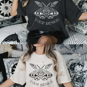 May include: A white and a charcoal gray t-shirt with a black and white graphic of a moth with moon phases and the text "YOUR DESIGN" printed on the front.
