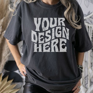 Puede incluir: Una camiseta gris oscuro de gran tama&ntilde;o con un gr&aacute;fico blanco de estilo vintage que dice "YOUR DESIGN HERE".