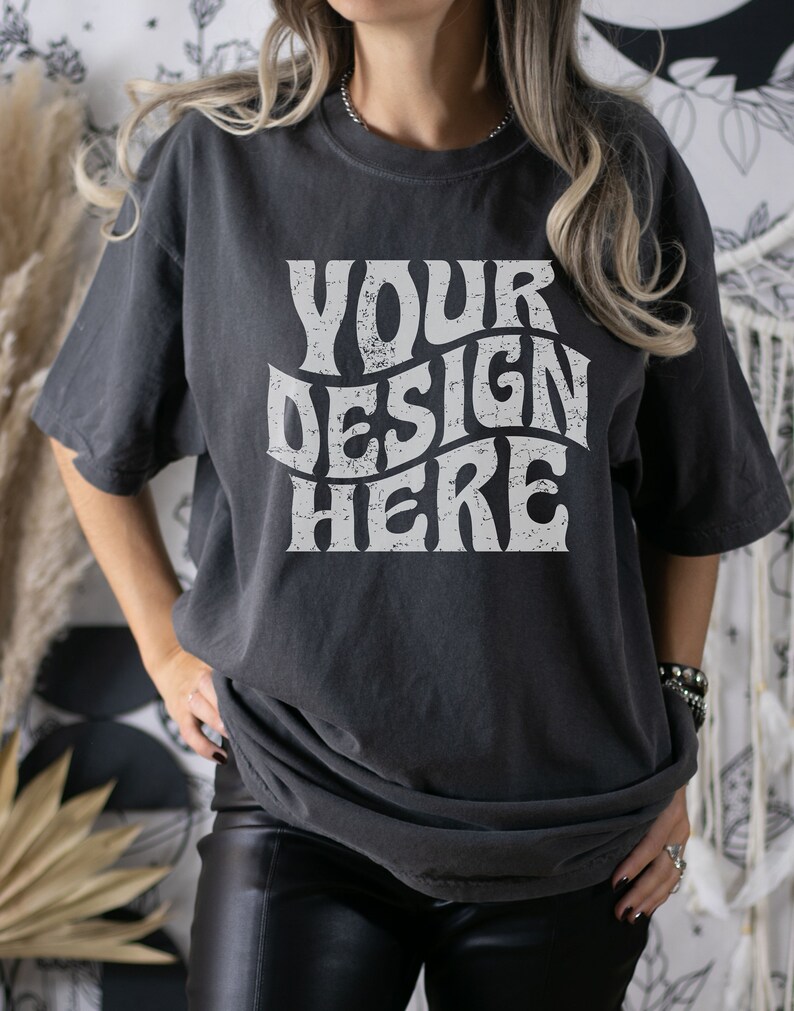 Puede incluir: Una camiseta gris oscuro de gran tama&ntilde;o con un gr&aacute;fico blanco de estilo vintage que dice "YOUR DESIGN HERE".