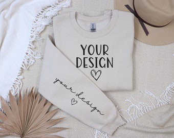 May include: A beige sweatshirt with the text "YOUR DESIGN" and a heart on the front and the text "your design" with a heart on the sleeve.
