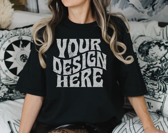 May include: Black t-shirt with a white graphic that says "YOUR DESIGN HERE" in a retro font.