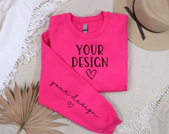 May include: A bright pink sweatshirt with the text "YOUR DESIGN" and a small heart on the front. The text "your design" and a heart are also on the sleeve.