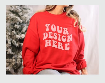 May include: Red sweatshirt with long sleeves and a crew neck. The sweatshirt has the text "YOUR DESIGN HERE" printed in pink on the front.