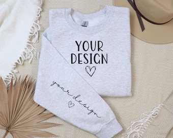 May include: A gray sweatshirt with the text "YOUR DESIGN" and a heart on the front. The text "your design" is written in cursive on the left sleeve with a heart.