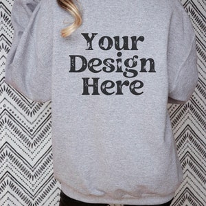 Puede incluir: Una sudadera gris con el texto "Your Design Here" impreso en la espalda.