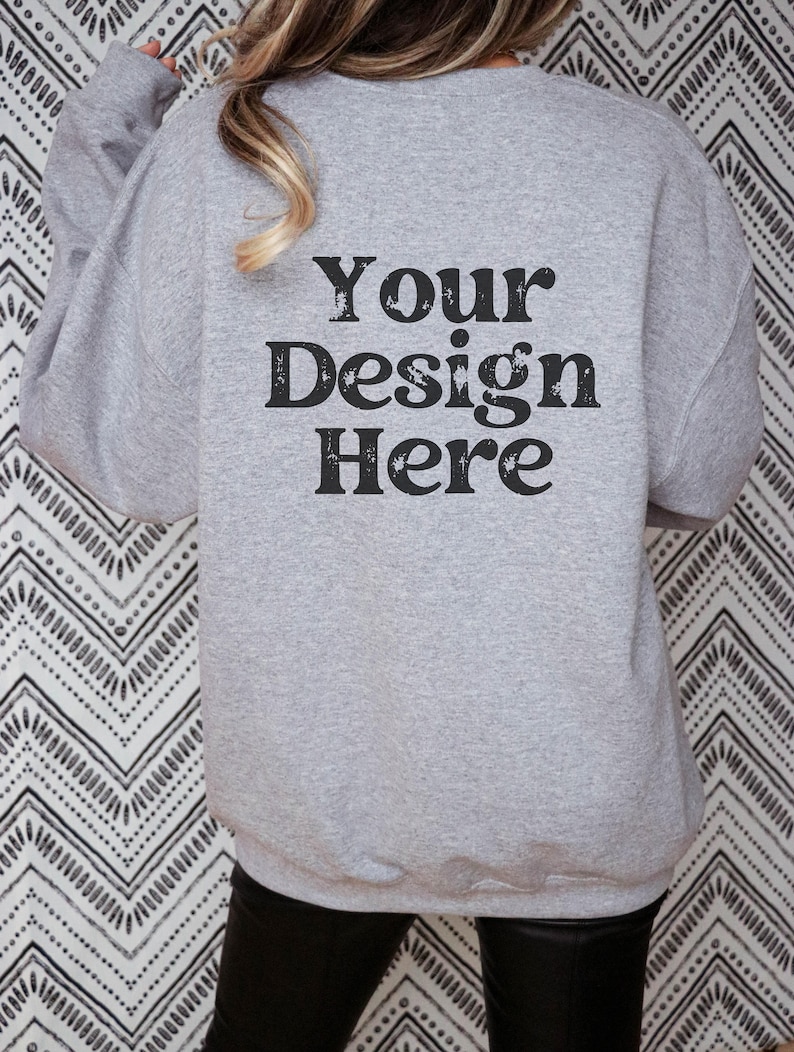 Puede incluir: Una sudadera gris con el texto "Your Design Here" impreso en la espalda.
