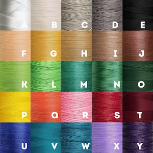 Puede incluir: Una tabla de 25 carretes de hilo de varios colores, etiquetados con letras de la A a la Y. Los carretes est&aacute;n dispuestos en una cuadr&iacute;cula de cinco filas y cinco columnas.