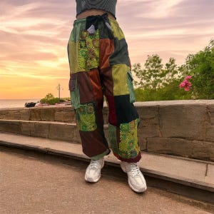 Puede incluir: Pantalones de patchwork con una variedad de colores y texturas, incluyendo marr&oacute;n, verde y rojo. Los pantalones tienen una cintura con cord&oacute;n y grandes bolsillos cargo.