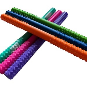 Puede incluir: Un conjunto de palitos de dentición coloridos en verde, azul, naranja, rosa y morado. Cada palito tiene una superficie con textura y ranuras. Los palitos están dispuestos en forma de abanico sobre un fondo blanco, para bebés.