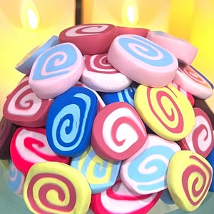 May include: A colorful assortment of swirl-patterned, candy-like decorations in pink, blue, yellow, and red.