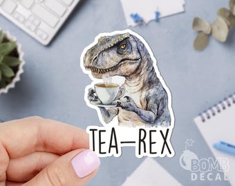 May include: A watercolor illustration of a green Tyrannosaurus Rex dinosaur holding a cup of tea. The dinosaur is wearing a white teacup and saucer. The text "TEA-REX" is written below the dinosaur.