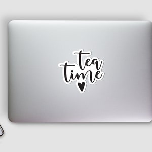 K&ouml;nnte beinhalten: Ein schwarz-wei&szlig;er Aufkleber mit dem Text "tea time" und einem kleinen Herzen.
