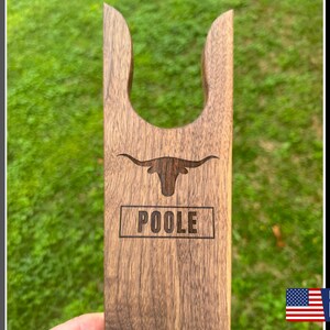 May include: A wooden boot jack with a longhorn steer design and the name "POOLE" engraved on it. Made in the USA.