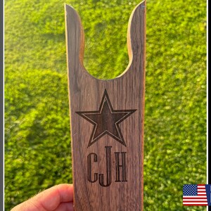 May include: A wooden boot jack with a star and the initials "CJH" engraved on it. Made in the USA.