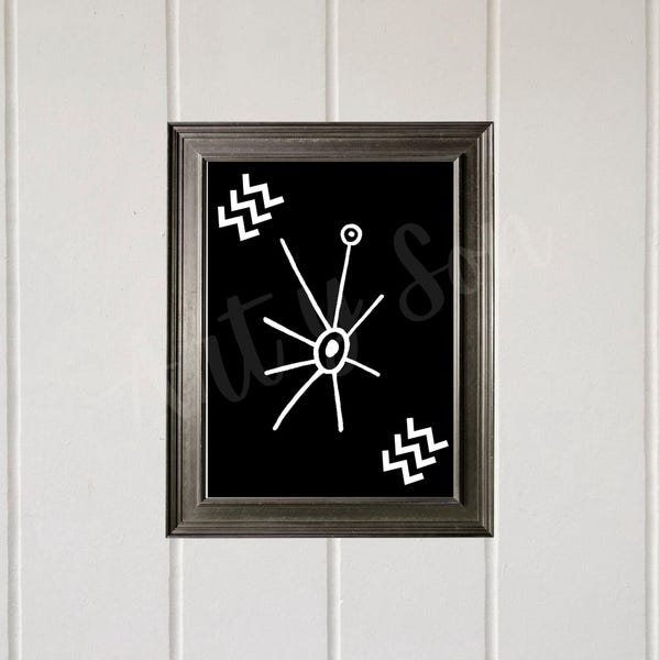 May include: A framed wall art piece featuring a black rectangular background with a white central starburst graphic, a small circle at the top, and two white zigzag patterns located in the upper left and lower right corners of the print.